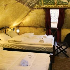 1 dormitorio con 2 camas en una tienda de campaña en Excalibur miniHotel, en Eger