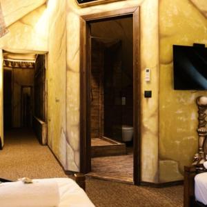 a room with a mirror and a tv on a wall at Excalibur miniHotel in Eger