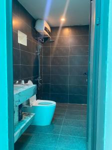 ein Badezimmer mit einem blauen WC und einem Waschbecken in der Unterkunft Family Home Villa Bà Nà Sun World 