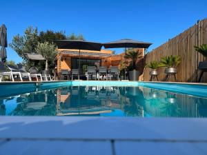 GourgéBois Mort farm的后院的带椅子和遮阳伞的游泳池