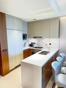 a kitchen with white counters and wooden cabinets at The address opera t1 burj khalifa in Dubai
