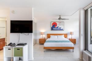 1 dormitorio con 1 cama y TV de pantalla plana en 7th Floor Garden View Condo In Walking Distance to Waikiki Beach condo, en Honolulu