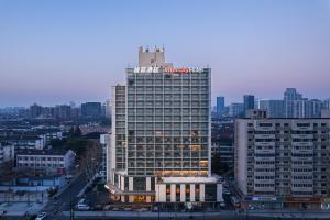 um edifício alto com um sinal em cima em Intercity Hangzhou West Lake Huanglong Hotel em Hangzhou