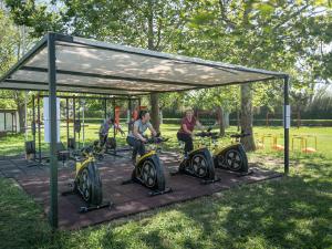 a group of people sitting on exercise bikes under a canopy at Grecotel LUXME Costa Botanica in Acharavi