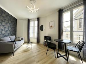 una sala de estar con un sofá y una mesa en Le Lumineux - Cœur de Ville, en Chartres