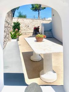une table blanche assise au-dessus d'une terrasse dans l'établissement Anemos Studios, à Adamas