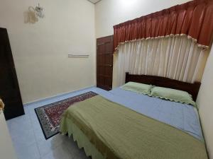 a bedroom with a bed with a wooden headboard at Rumah Teratak Bonda in Jertih