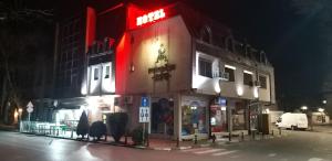 un edificio iluminado en una calle por la noche en Hotel Rio en Nova Zagora