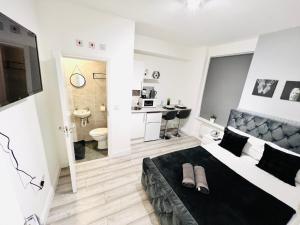 una camera con letto bianco e nero e un bagno di Central studios in top location a Londra