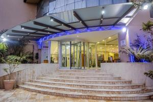 eine Treppe vor einem Gebäude mit blauen Lichtern in der Unterkunft Liberté Hotels Oran in Oran