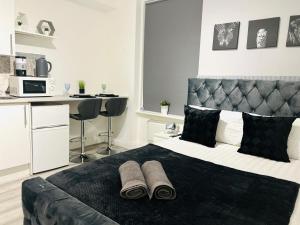 una camera da letto con un grande letto con due pantofole sopra di Central studios in top location a Londra