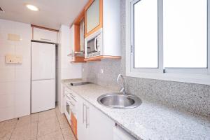 a kitchen with a sink and a microwave at Apartaments Marina - Abapart in Barcelona