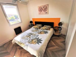 um quarto com uma cama com uma cabeceira laranja em T2 Cosy ₪ Residence Securise ₪ Airbus ₪ Piscine em Colomiers
