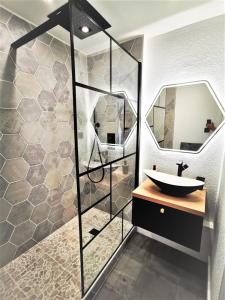 uma casa de banho com um lavatório e um espelho em T2 Cosy ₪ Residence Securise ₪ Airbus ₪ Piscine em Colomiers