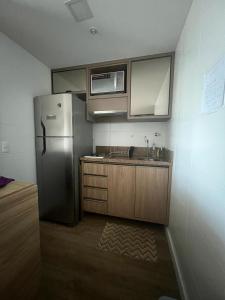 a kitchen with a refrigerator and a sink at Aparthotel Astron in Salvador