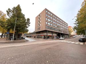 a large building on a city street with a road at Aparthotel Clock 2 in Kotka