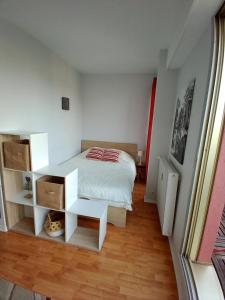 a small bedroom with a bed and a desk at Appartement avec parking et balcon vue Cathédrale in Chartres
