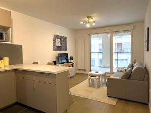 a kitchen and living room with a couch and a table at GoodGuest-Cosy Apartment New Bulding Clichy-4 PAX in Clichy
