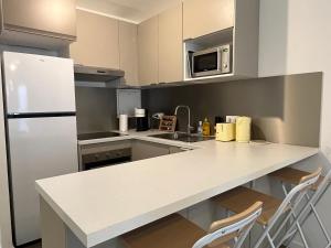 cocina con encimera blanca y nevera en GoodGuest-Cosy Apartment New Bulding Clichy-4 PAX en Clichy