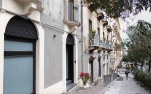 eine Stadtstraße mit Gebäuden mit Blumen auf dem Bürgersteig in der Unterkunft Opera Boutique in Catania