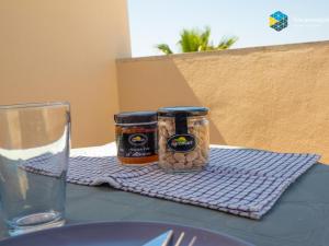 a table with two jars of pickles and a glass of water at Apartamento Bonanza in Colonia Sant Jordi +32 photos