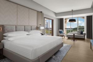 プトラジャヤにあるプトラジャヤ マリオット ホテルのベッドルーム(大きな白いベッド1台付)、リビングルームが備わります。