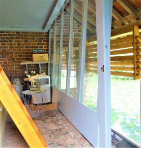 un porche cubierto con mesa y ventana en Le Lavoir Secret - hébergement atypique dans un joli cadre bucolique, en Dangeau
