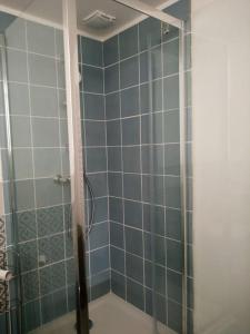 y baño con ducha de azulejos azules. en Typique cabanon provençal rénové Attention escalier extérieur pour accéder au 1er étage, en Gonfaron