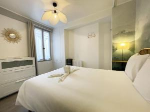a bedroom with a white bed with a towel on it at The Heart of Chartres in Chartres