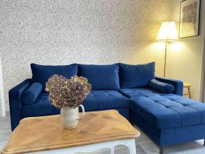 a blue couch in a living room with a table at The Heart of Chartres in Chartres