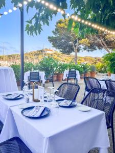 una mesa con manteles blancos y sillas en un restaurante en Hôtel Helios & SPA - Ile des Embiez en Six-Fours-les-Plages
