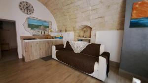 sala de estar con sofá y reloj en la pared en La Nicchia, en Ragusa