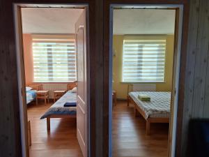 a room with two beds and a room with two windows at Jūras sāga in Pāvilosta +5 photos