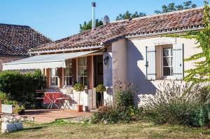 Casa blanca pequeña con porche y ventana en Les Granges Lestang, en Sainte-Innocence