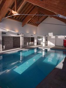 a swimming pool with blue water in a building at Le hameau des Rennes in Vars