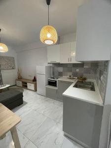 プトレマイスにあるVPG Central Luxury Apartmentの白いキャビネットとシンク付きのキッチンが備わります。