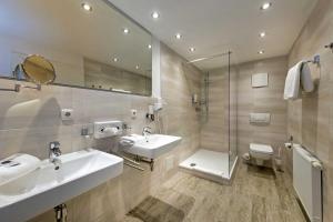 a bathroom with two sinks and a toilet and a mirror at Hotel Leuchtfeuer in Freest