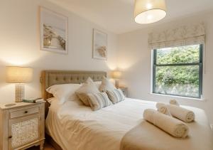 a bedroom with a white bed with pillows and a window at A7 Masts in Torquay