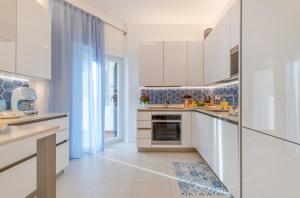 een witte keuken met witte kasten en een raam bij Rosamarina in Sorrento