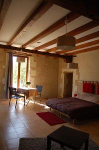 a bedroom with a bed and a table in a room at Haras des Hayes in Tresson