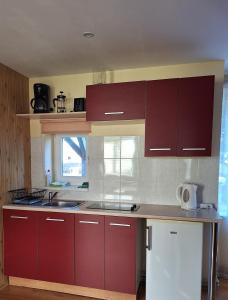 a kitchen with red cabinets and a counter top at Jūras sāga in Pāvilosta