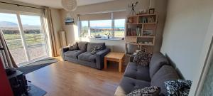 una sala de estar con 2 sofás y una ventana grande en Gort Lodge en Portmagee