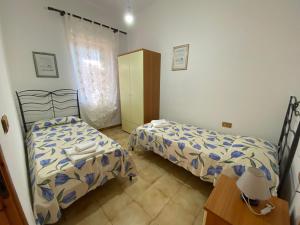 ブドーニにあるBudoni Centroのベッドルーム1室(ベッド2台、ランプ付きテーブル付)