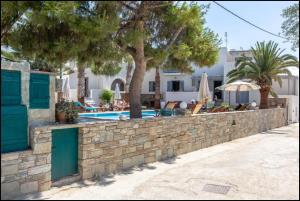 a stone retaining wall next to a swimming pool at Ampelos Prokopios in Agios Prokopios