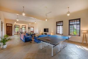 a living room with a ping pong table at SaffronStays Mograa laffaire in Alibaug