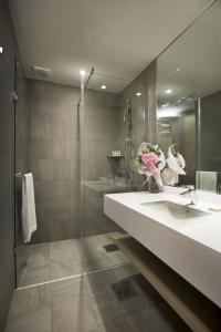 y baño con lavabo y ducha con espejo. en Arirang Hill Hotel Dongdaemun, en Seúl