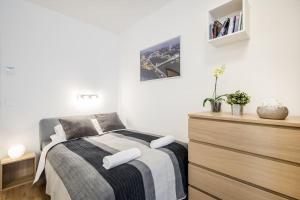 a bedroom with a bed and a wooden dresser at Marina apartment at Danube - FREE PRIVATE PARKING! in Budapest