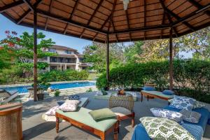 an outdoor patio with couches and a pool at SaffronStays Mograa laffaire in Alibaug