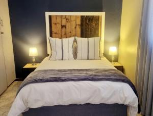 a bedroom with a large bed with two lamps at Summerville Place in Addo