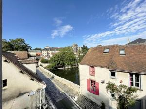 uma vista para um rio entre dois edifícios em Au fil de l’Eure, quartier authentique et plein de charme em Chartres